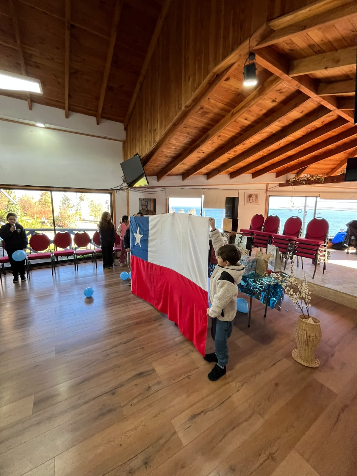 Estudiantes participando en una actividad comunitaria con la bandera de Chile